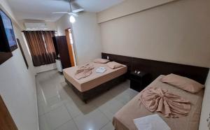 a hotel room with two beds and a window at Portal Palace Hotel in Aparecida