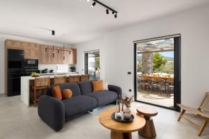 a living room with a blue couch and a kitchen at Villa Celestia in vlicha