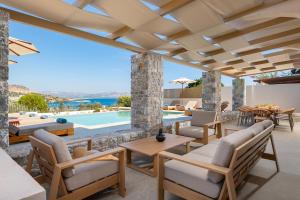 a patio with tables and chairs and a swimming pool at Villa Celestia in vlicha