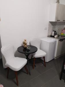 a kitchen with a table and four chairs and a small table with a table at Valencia in Vršac
