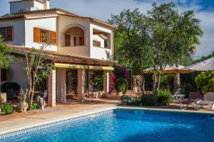 a villa with a swimming pool in front of a house at Villa Morea in Manacor +37 photos