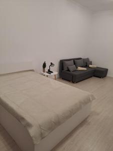 a bedroom with a large bed and a couch at Studio One in Făgăraş