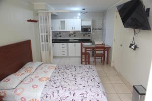 een slaapkamer met een bed en een keuken met een tafel bij Hostal Real in Lima