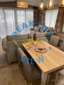 uma sala de estar com uma mesa e um sofá em Peaktop View, Winscales, Cumbria em Winscales