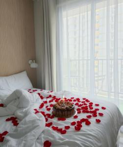 a bunch of red roses on a bed with a candle at Cabin916 condotel in Suba