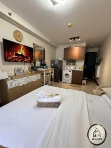 a room with a large white bed and a kitchen at Cabin916 condotel in Suba