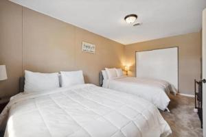 Dos camas en una habitación de hotel con sábanas blancas. en Minutes to Notre Dame - The Light on Brighton, en South Bend