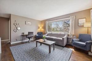 una sala de estar con un sofá y una mesa en Minutes to Notre Dame - The Light on Brighton, en South Bend