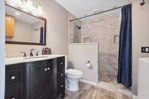 Un baño con lavabo, inodoro y ducha. en Minutes to Notre Dame - The Light on Brighton, en South Bend