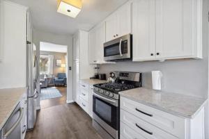 Una cocina con gabinetes blancos y un horno de estufa. en Minutes to Notre Dame - The Light on Brighton, en South Bend