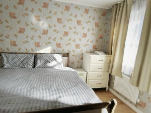 - une chambre avec un lit et un papier peint fleuri dans l'établissement Salford Detached House with Ensuite King Room, à Manchester