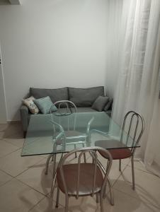 a living room with a glass table and two chairs at Sobrado Harmonia in Ponta Grossa