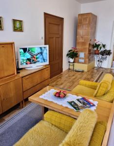 a living room with a table and a tv at Apartment in a historical house in the center of Levoča in Levoča