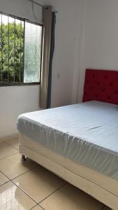 a bed sitting in a room with a window at Casa 28 de agosto climatizada e aconchegante in Manaus