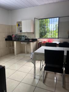 a kitchen with a table and chairs in a room at Casa 28 de agosto climatizada e aconchegante in Manaus