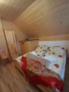a bedroom with a bed in a wooden cabin at Domki nad Borem in Male Ciche