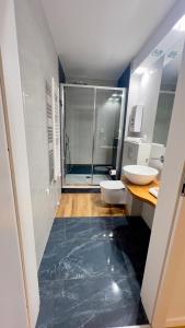 a bathroom with two toilets and a glass shower at Apartamenty Dąbrówka Beauty - w parku leśnym , sauna in Jelenia Góra +18 photos