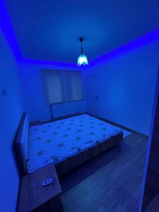 a room with a bed with a blue light at Emir's Apartment in Pristina
