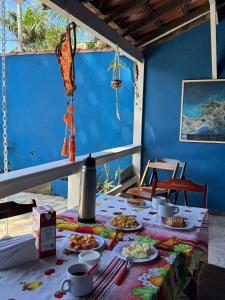 ブジオスにあるLa Casa Agus Hospedagemの青い壁に料理の皿が置かれたテーブル