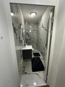 a bathroom with a sink and a mirror at Emir's Apartment in Pristina +2 photos