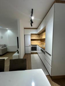 a kitchen with white cabinets and a white table at Emir's Apartment in Pristina