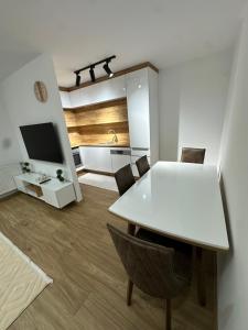 a kitchen and dining room with a white table and chairs at Emir's Apartment in Pristina