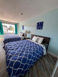 een blauwe slaapkamer met 2 bedden en een raam bij Ambassador Inn in Manchester +33 foto's