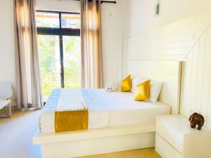 a bedroom with a large bed with yellow pillows at Trident Kandy in Kandy +32 photos
