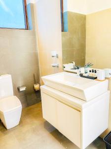 a bathroom with a white sink and a toilet at Trident Kandy in Kandy