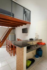 une cuisine avec un comptoir et une table avec des chaises dans l'établissement Apartamento de Frente pro Mar com Vista Incrível - 10 min da Praia do Morro, à Guarapari