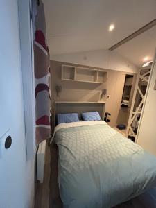 ein Schlafzimmer mit einem Bett in einem kleinen Zimmer in der Unterkunft mobil home in La Tremblade