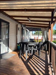 eine Terrasse mit Tisch und Stühlen auf einem Deck in der Unterkunft mobil home in La Tremblade