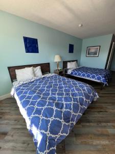 1 Schlafzimmer mit 2 Betten und blauer Decke in der Unterkunft Ambassador Inn in Manchester + 33 Fotos