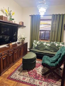 a living room with a couch and a chair at Casa com piscina em Nogueira - 6 pessoas in Araras Petropolis +11 photos