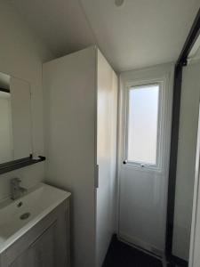 ein Badezimmer mit Waschbecken und Fenster in der Unterkunft mobil home in La Tremblade