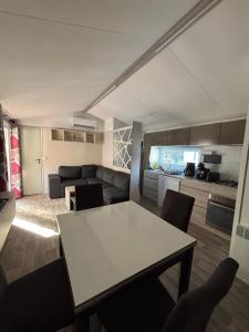 eine Küche und ein Wohnzimmer mit Tisch und Stühlen in der Unterkunft mobil home in La Tremblade