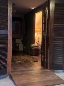 a hallway with a door open to a living room at Casa com piscina em Nogueira - 6 pessoas in Araras Petropolis