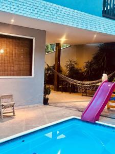 a swimming pool with a slide in a house at Casa com piscina em Nogueira - 6 pessoas in Araras Petropolis