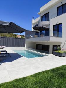 a villa with a swimming pool in front of a house at Αriadne in Porto Rafti +21 photos