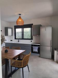 a kitchen with a wooden table and a refrigerator at Αriadne in Porto Rafti