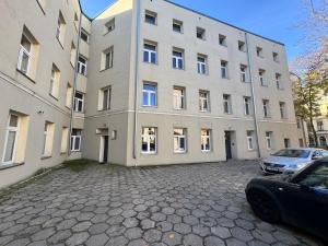 a large building with cars parked in front of it at Apart Complex Green Rewolucji 27 in Łódź