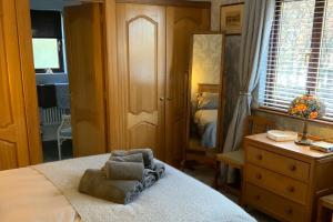 ein Schlafzimmer mit einem Bett mit einem Stuhl darauf in der Unterkunft Remarkable 2-Bed Cottage in tranquil setting in Wooler