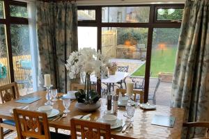 ein Esszimmer mit einem Tisch und einem großen Fenster in der Unterkunft Remarkable 2-Bed Cottage in tranquil setting in Wooler