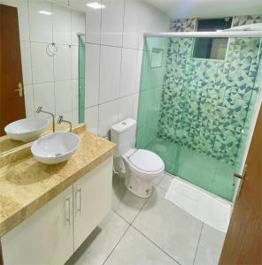 a bathroom with a toilet and a glass shower at Kitnet Aconchego in São João del Rei