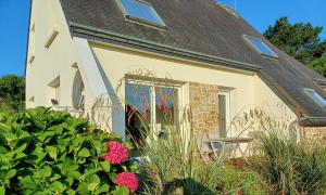 une maison avec une porte d'entrée avec des fleurs dans l'établissement Komforthaus Mit Traumgarten Und Meerblick, à Plouha