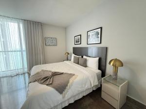 a white bedroom with a bed and a night stand at Yoo Panama in Panama City +291 photos