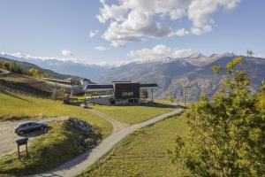 a car parked at a gas station with mountains in the background at Appartamenti Pila Vacanze 2 in Cerise