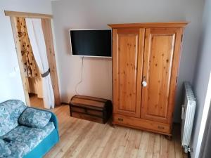 a living room with a couch and a tv and a cabinet at Appartamenti Pila Vacanze 2 in Cerise
