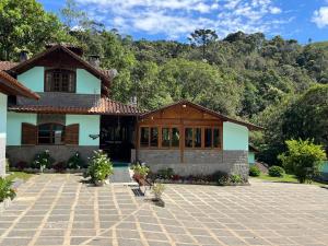 een huis met een stenen oprit ervoor bij Pousada Brilho da Natureza in Visconde De Maua