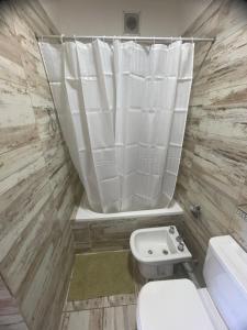 ein Badezimmer mit Toilette und Duschvorhang in der Unterkunft La Juanita in San Juan